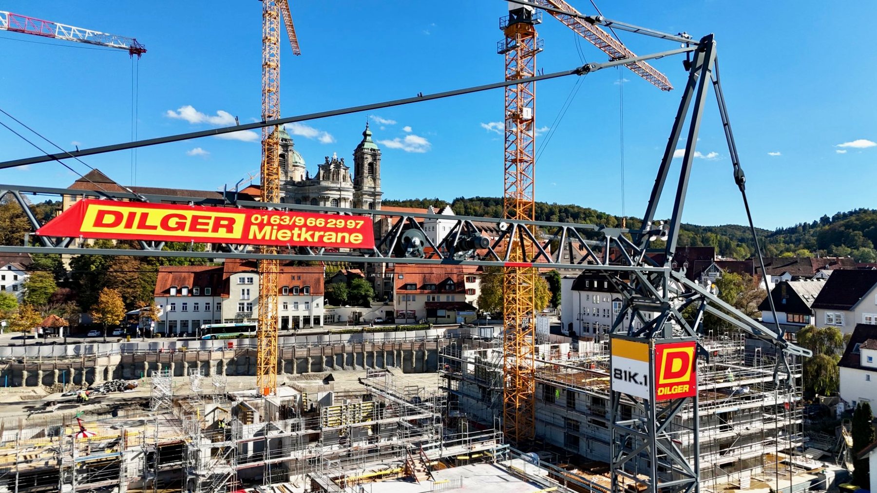 DILGER-Mietkran 81 K.1 mit Werbebanner auf einer Baustelle